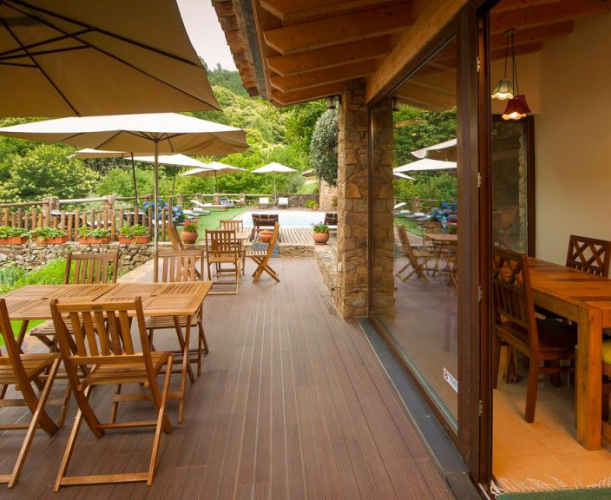 Jardin vert et espace extérieur avec des tables et des chaises de l'hébergement des circuits de Freeride Spirit dans les montagnes de Lousã au Portugal